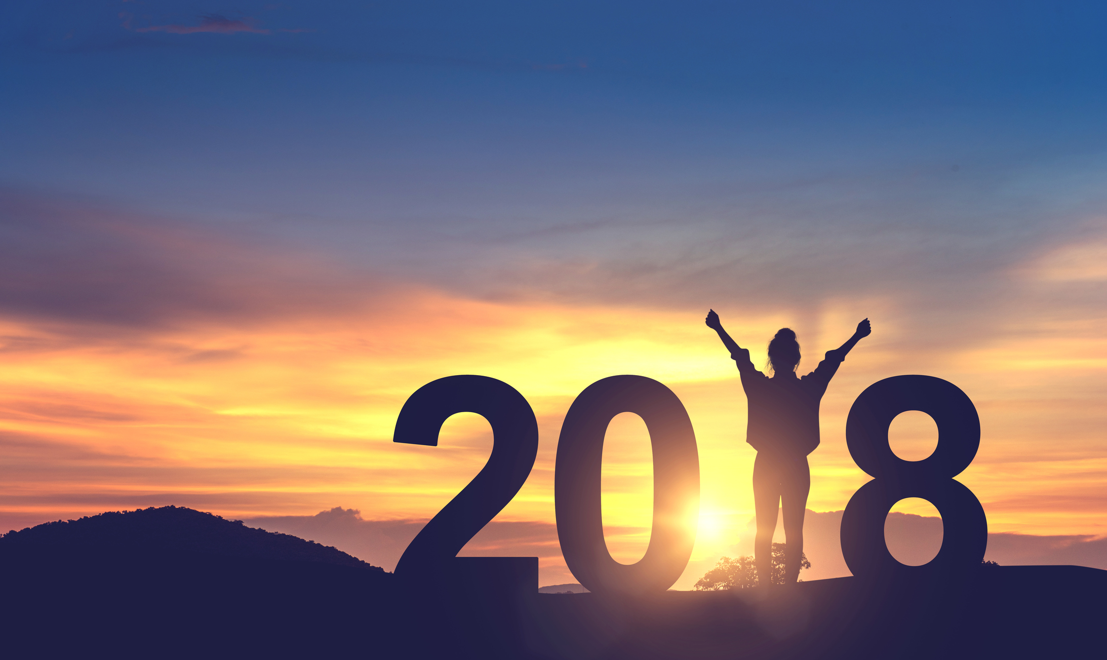 Silhouette young woman enjoying on the hill while forming a 2018 year